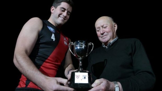 Aaron Bruce with former Manuka Football Club player Jacko Pini and the Neil Conlan Trophy.  Eastlake will be holding a premiership anniversary weekend to celebrate their three-peat from 1973-75.