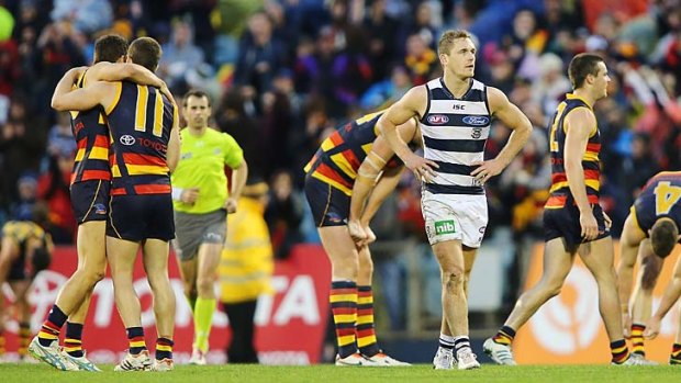 What happened? Geelong skipper Joel Selwood is dumbfounded as the Crows celebrate a shock win.