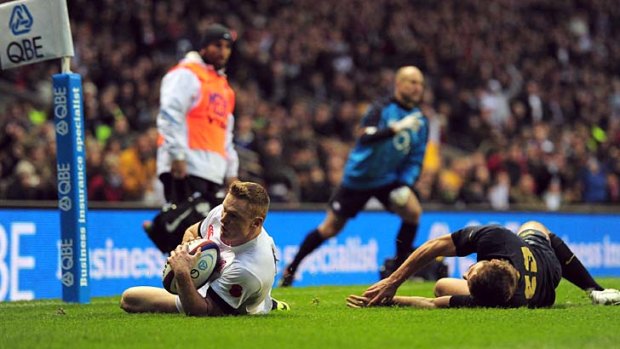 Chris Ashton of England beats the tackle of Santiago Cordero of Argentina to score a try.