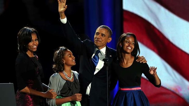 President Barack Obama walks on stage with first lady Michelle Obama and daughters Sasha and Malia to deliver his victory speech on election night.