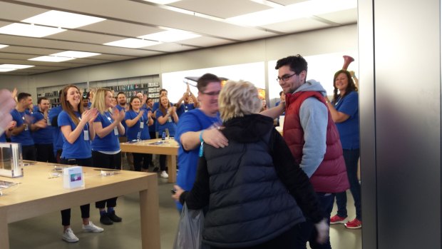 David Brown, first in line at Chadstone, gets a hug from Apple staff as doors opened.