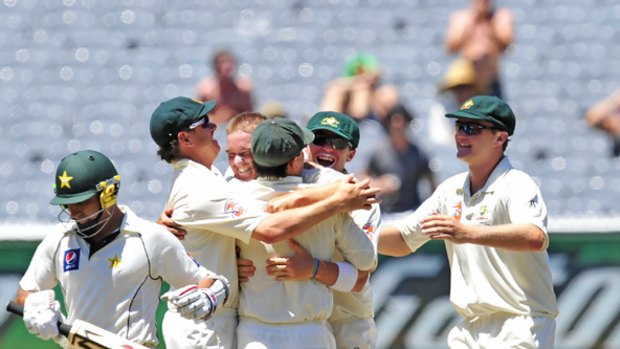 Australian players rush to celebrate with Nathan Hauritz after the spinner took his fifth wicket for the innings against Pakistan yesterday. Hauritz also scored 75 in Australia's first innings.