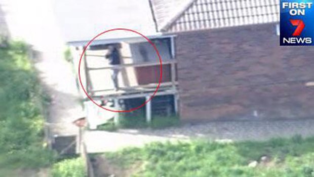 Seven News tweeted an image of a man standing on the balcony of the property with what appeared to be a gun pointed at their helicopter.