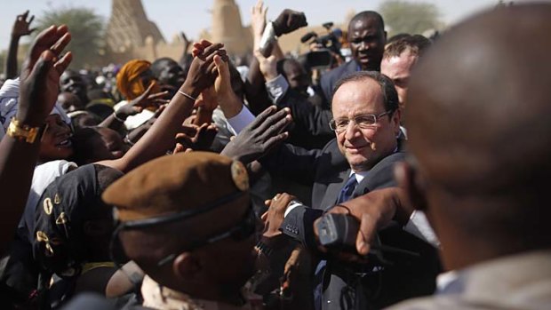 ''The most important day of my political life'' ... Francois Hollande plunges into the middle of an ecstatic crowd in Timbuktu.