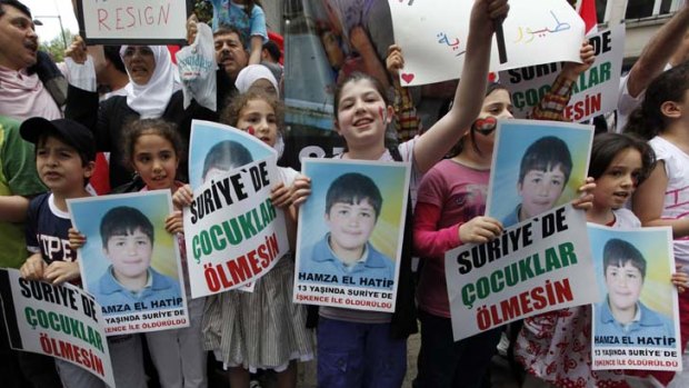 Children carry pictures of 13-year-old Hamza al-Khatib during a protest near the Syrian Consulate in Istanbul.