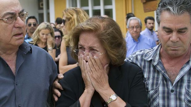 The mother, centre, and father, left, of Cypriot media boss Andis Hadjicostis leave the court after hearing the verdict.