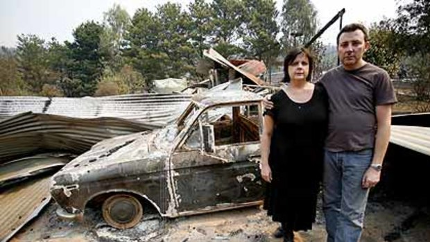 Ian and Annemarie Harris stand in front of the burnt remains of their house, about 10 kms south of Stanley.