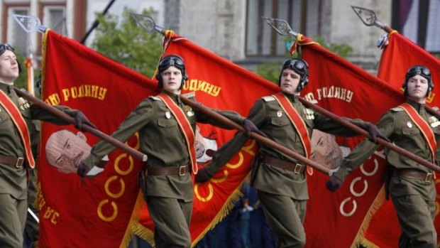 Soldiers march carrying flags displaying portraits of the Soviet state founder, Vladimir Lenin, at Red Square in Moscow in 2008.