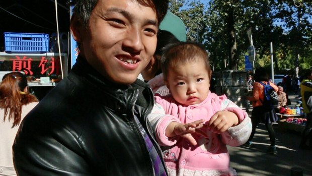 Ma Qingtian, with his one-year-old daughter, says it would be  "wonderful" to have a second child but financial pressures make it unrealistic. 