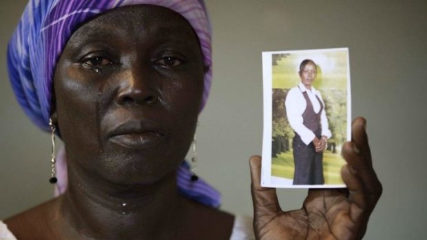 Martha Mark, the mother of kidnapped schoolgirl Monica Mark cries as she displays her photo, in the family house, in Chibok, Nigeria. More than 200 schoolgirls taken by Islamist group Boko Haram are still missing.