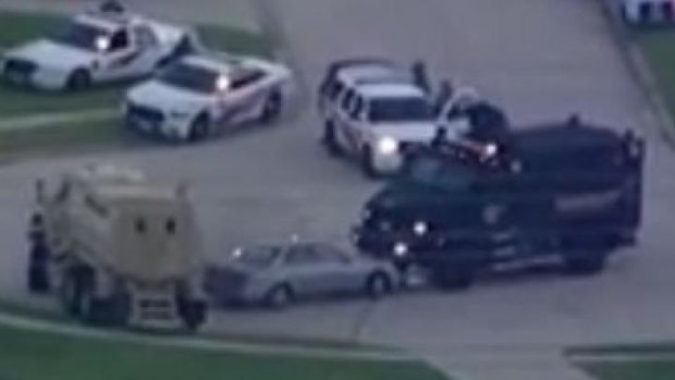 Armoured vehicles surround the suspect's car.