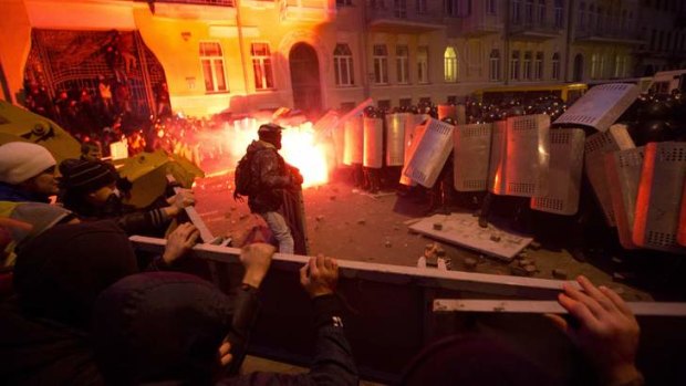 Protesters throw stones as they clash with police outside the presidential administration building in downtown Kiev, Ukraine.
