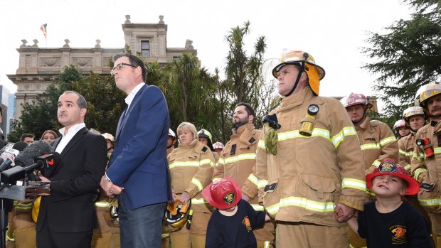 Voluntary and paid CFA members stand with Premier Daniel Andrews and new Emergency Services Minister James Merlino on Friday.