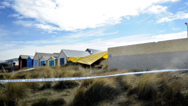 Man hunt ... Police tape and a tarpaulin cover the 'crime scene' outside the public toilet block at Edithvale beach, where the young woman claimed she was raped and stabbed.