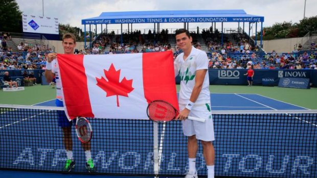 Vasek Pospisil (L) and Milos Raonic of Canada pose with the Canadian flag before the start of the mens final of the Citi Open.