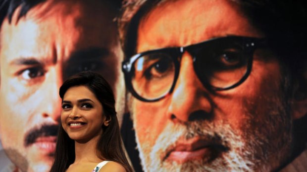 Deepika Padukone at a press conference promoting the controversial movie Aarakshan. The background shows co-stars Saif Ali Khan and Amitabh Bachchan.