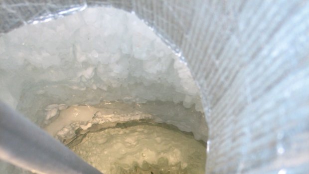 A sensor is lowered into the hole of an IceCube string. The deployment of each of the IceCube strings lasted about 11 hours. In each hole, 60 sensors were quickly installed before the ice froze around them.