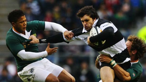 Adam Ashley-Cooper (C) of the Barbarians is tackled by Elton Jantjies (L) and Andries Strauss (R) of South Africa.