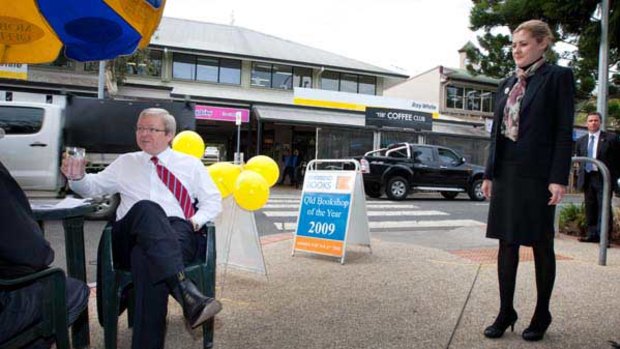 Kevin Rudd speaks to constituents at a mobile office in Bulimba while LNP candidate Rebecca Docherty waits to introduce herself.