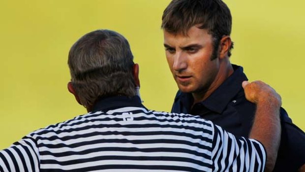 A PGA rules official tells Dustin Johnson the bad news on the 18th green.