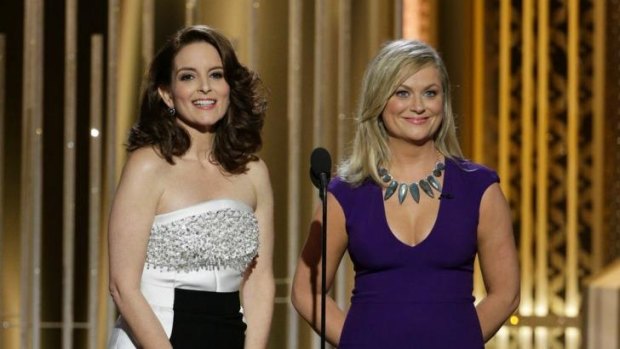 Golden Globes co-hosts Tina Fey, left, and Amy Poehler cracked the Bill Cosby gag to stilted laughter.