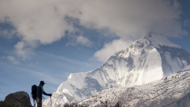 Thousands of tourists hike the Annapurna Circuit in Nepal in October each year. This photo show a man looking at Dhaulagiri I mountain (8167m) near Jomsom.