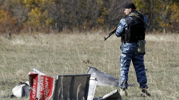 A policeman representing Donetsk People's Republic stands guard at the crash site of the downed Malaysia Airlines flight MH17, near the village of Grabovo.