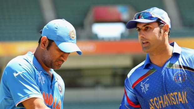 MS Dhoni (L) of India and Mohammad Nabi of Afghanistan shake hands at the coin toss.