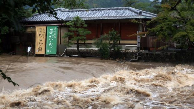 Flood water runs next to a sweet shop in Kyoto, western Japan.
