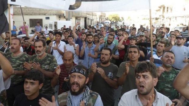 Members of the Free Syrian Army and residents shout slogans during a protest against Syria's President Bashar al-Assad in Sermada near Idlib.