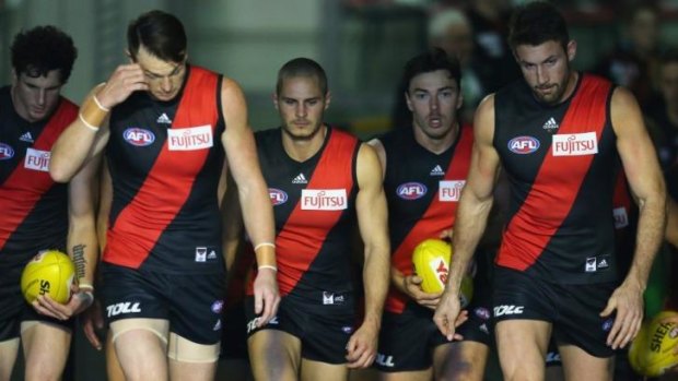 Distracted: Essendon players walk out for the game against Melbourne on Sunday.