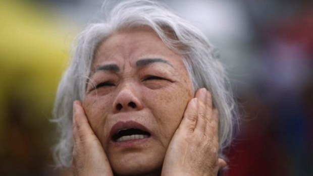 Terrible wait: A family member of a missing passenger from the capsized ship cries as she prays while waiting for news from rescue and salvage teams.