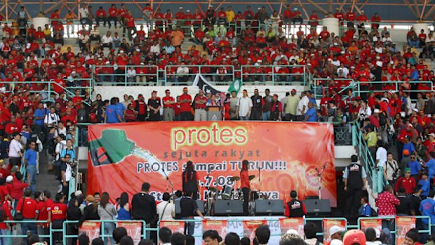 Against the odds: Despite police saying a rally was illegal and setting up roadblocks, Malaysian opposition supporters gather  to protest about rising fuel prices.