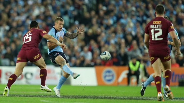 Blues halfback Trent Hodkinson puts boot to ball in the second State of Origin match against Queensland.