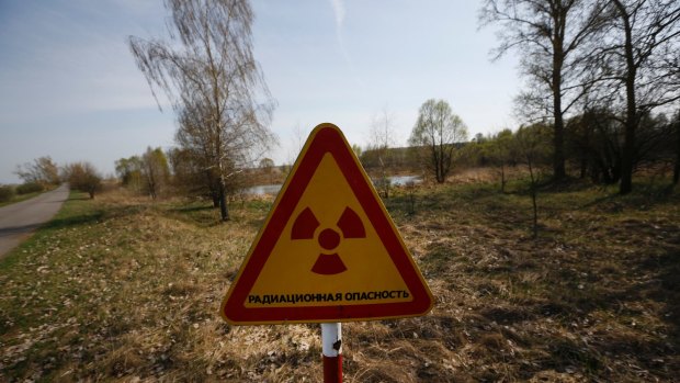 A radiation warning sign stands near a checkpoint in an exclusion zone around the Chernobyl nuclear reactor, southeast of Minsk, Belarus.