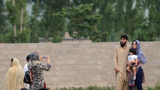 A Pakistani family poses for photographs in front of the final hiding place of al-Qaeda chief Osama bin Laden in Abottabad.