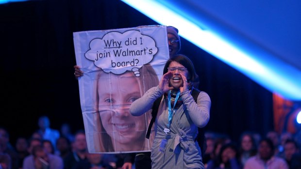 A protester shouts as Yahoo CEO Marissa Mayer speaks in conversation with Salesforce chairman and CEO Marc Benioff at the 2013 Dreamforce conference in San Francisco.