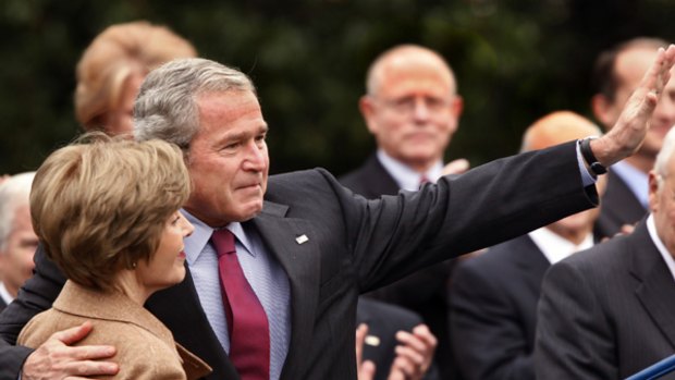 George Bush, accompanied by first lady Laura Bush, gives an emotional wave to White House staff.