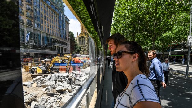 Passersby watch as the City Square site is excavated to make way for the underground Town Hall Station. 