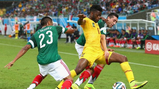 Sammy N'Djock of Cameroon is challenged by Jose Juan Vazquez (left) and Hector Herrera of Mexico in the first half in Natal.
