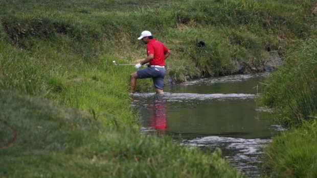 Paddling: Day wades back through a creek after playing out from the rough.