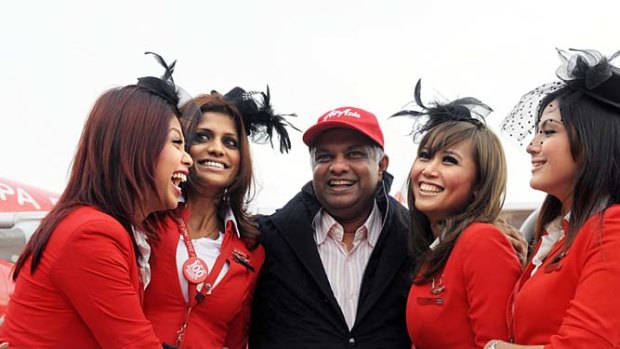 Plenty to smile about ... AirAsia chief executive Tony Fernandes (C) with flight attendants.