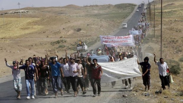 Yazidi refugees demonstrate near the Iraqi-Syrian border crossing.