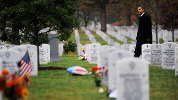 Honouring the fallen ... Barack Obama walks among headstones of US war dead from Iraq and Afghanistan after  Veterans Day ceremonies at Arlington National Cemetery, outside Washington.