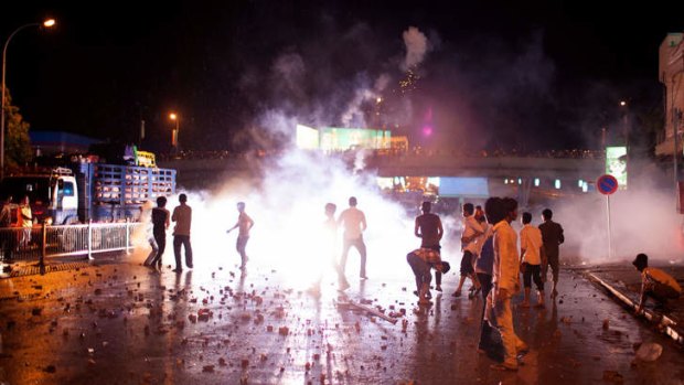 Cambodian protesters throw stones to police during clashes in Phnom Penh on September 15, 2013.