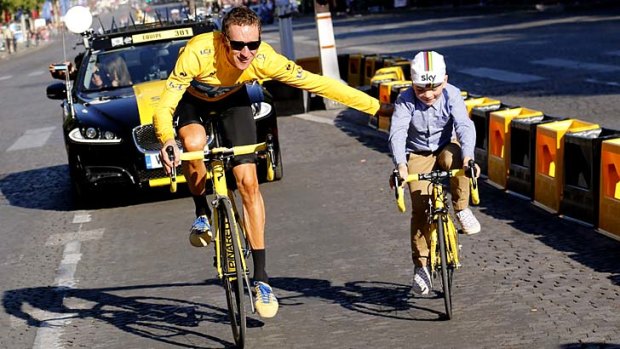 Father and son ... Tour de France winner Bradley Wiggins parades through Paris with his son, Ben.