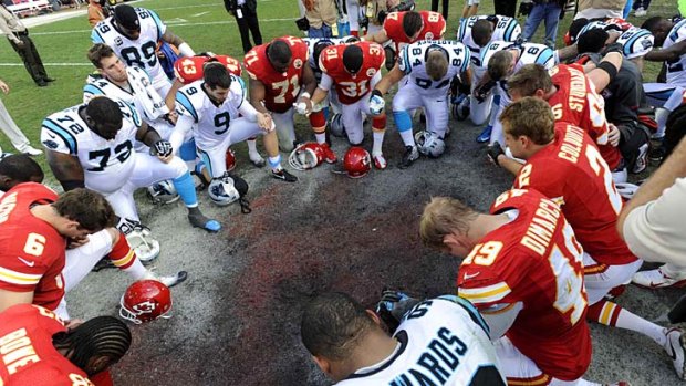 Kansas City Chiefs and Carolina Panthers players form a prayer circle after the Chiefs' win an NFL football mtach a day after one of their players was involved in a murder suicide in Kansas City.