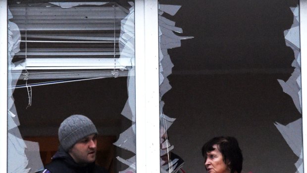 People repair windows in a flat after it was damaged by shelling in the eastern Ukrainian city of Donetsk.