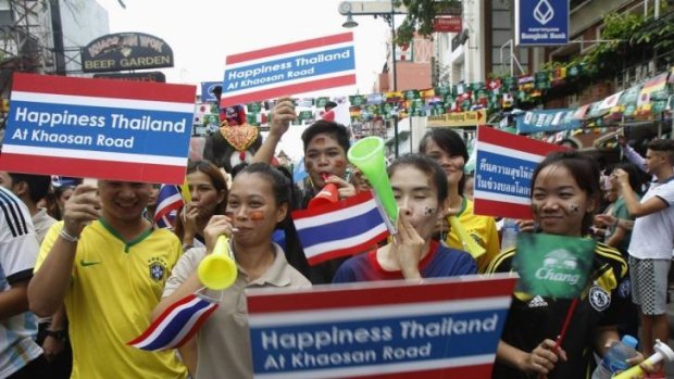 Workers hold placards during a celebration to boost tourism, along the Khaosan tourist street in Bangkok.