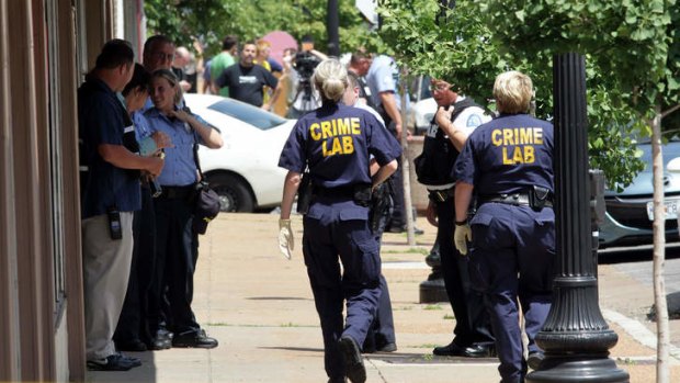 St. Louis police work the scene where four people were found dead in a business along Cherokee Street south of downtown in St. Louis, on Thursday, June 13, 2013.